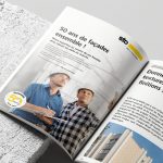 Un magazine posé sur un bloc de façade avec une annonce presse pour l'anniversaire Sto