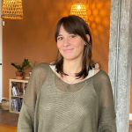 Camille, motion designer, debout dans l'agence Empreinte Conseil